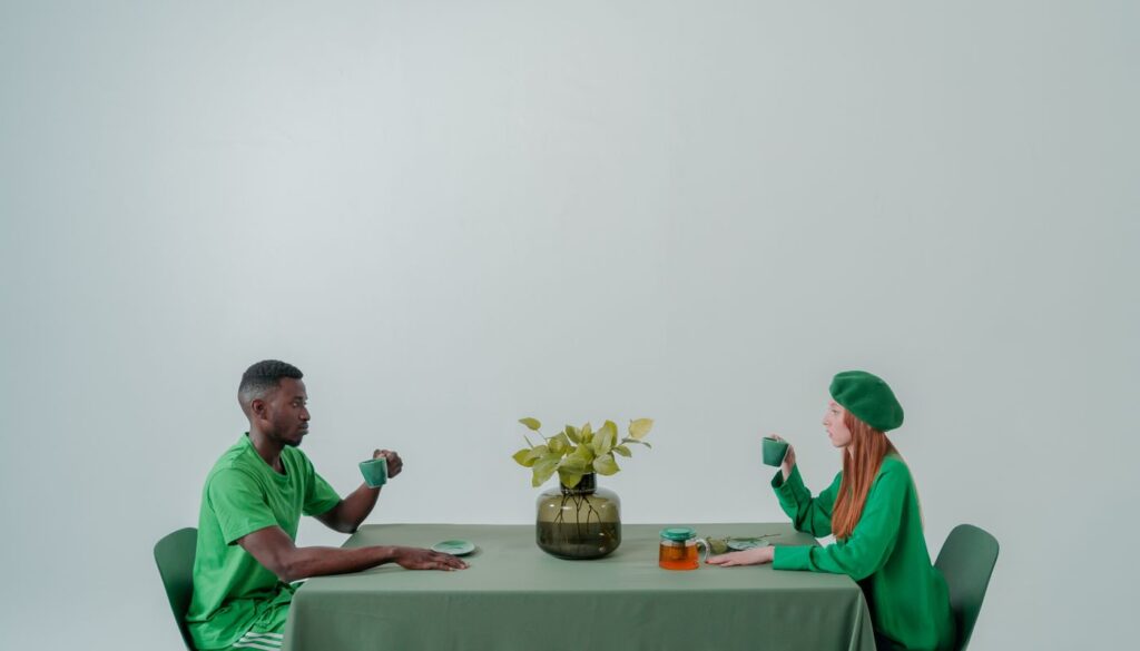 A coach and client talking across a table with mugs in hand during a relaxed lifestyle consultation