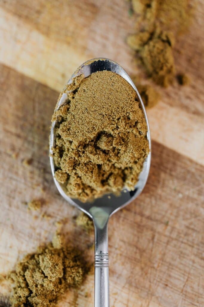 Ground cumin powder on a stainless steel spoon, the form most often used in Ayurvedic cooking