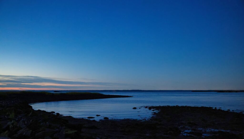 A still lake under a deep blue pre-dawn sky, the quiet hour before the sun clears the horizon