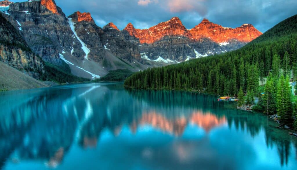 A still mountain lake reflecting sky and forest, illustrating the five elements that combine to form the three doshas