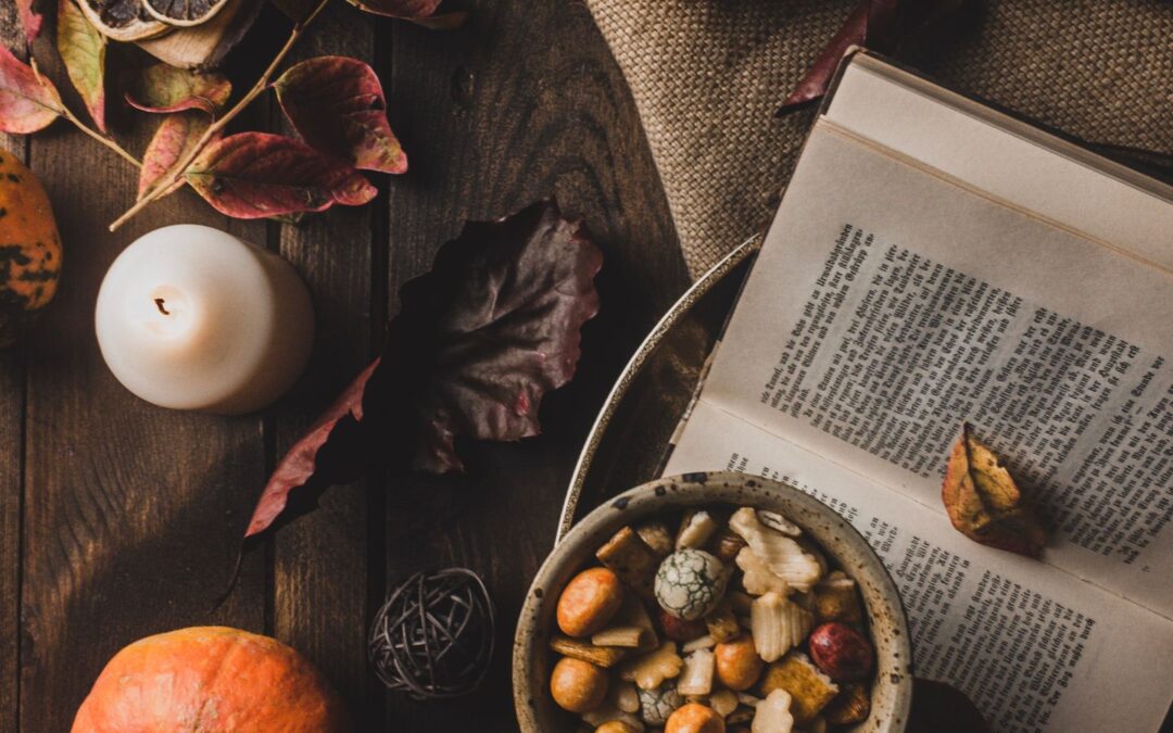 Open book beside a cup of tea on a wooden table, arranged as an inviting reading setup for studying Ayurveda