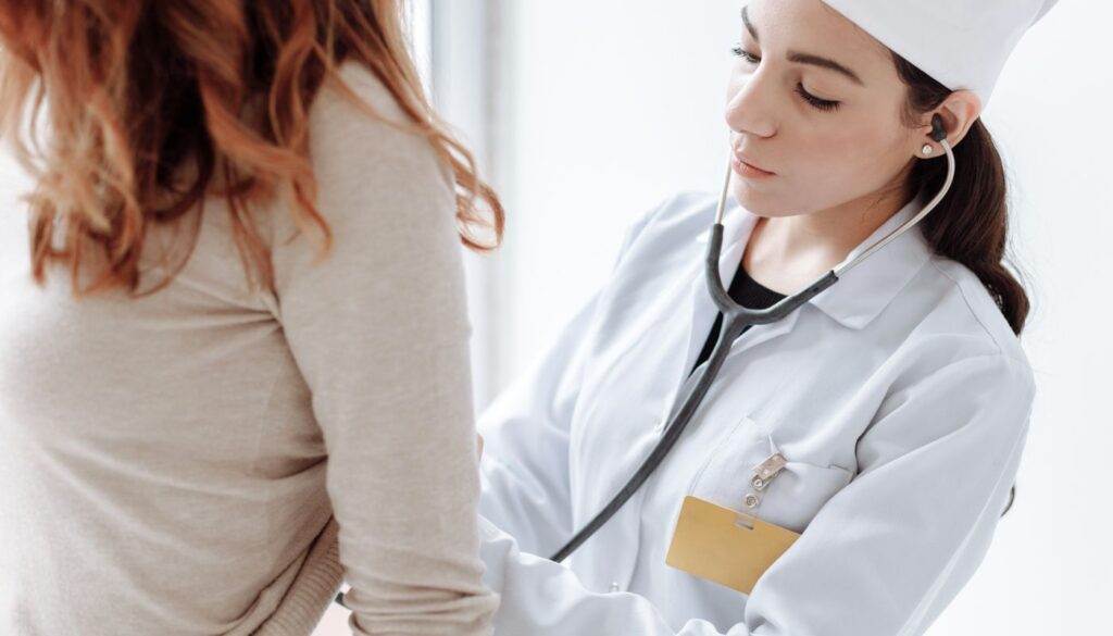 A practitioner sitting with a patient and checking them by hand, the kind of in-person assessment that confirms a body type