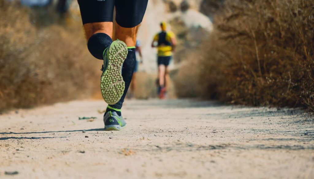 A runner pushing along a woodland trail, the kind of vigorous daily movement that clears accumulated kapha